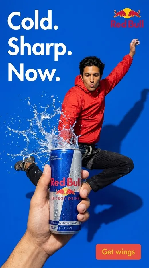 Red Bull ad — a climber leaps in mid-air spraying water beside a can, blue backdrop