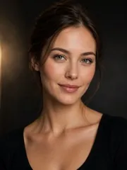 A soft-lit portrait with bare, natural makeup against a dark backdrop