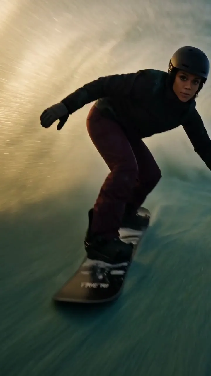 Sutra V-Maxx spec wellness ad. A snowboarder in a black helmet carving down a giant curling sand dune at dusk